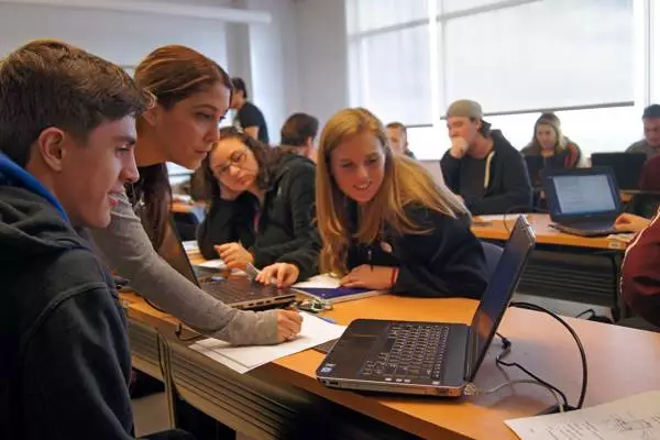 four students gathered around a computer