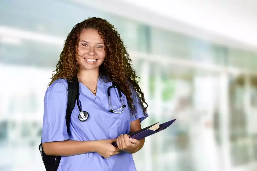 Nursing student standing with clipboard