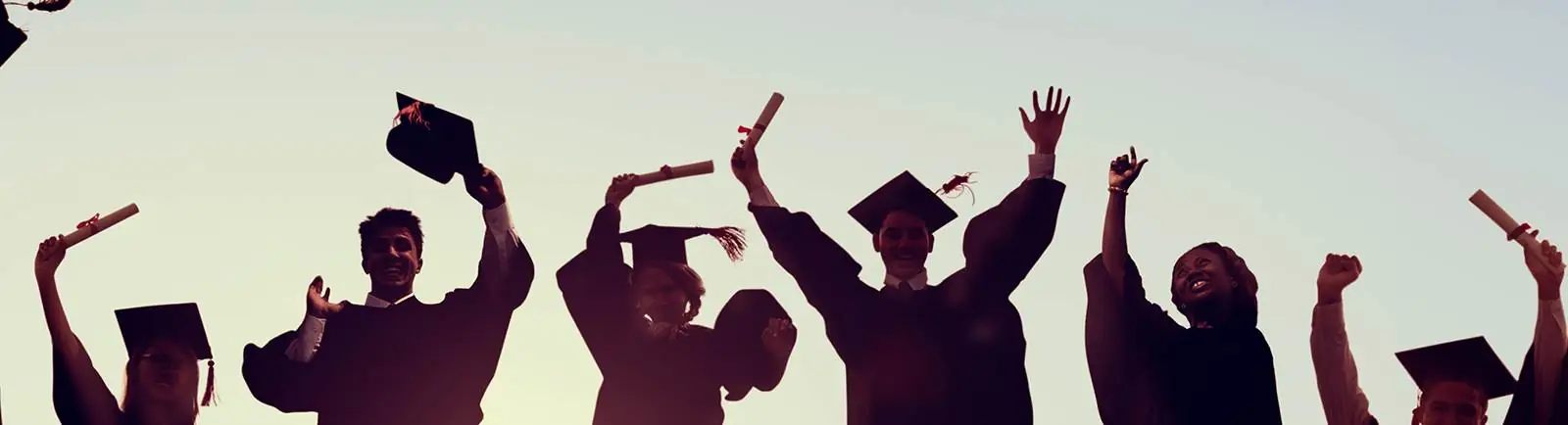 graduates at commencement tossing their caps