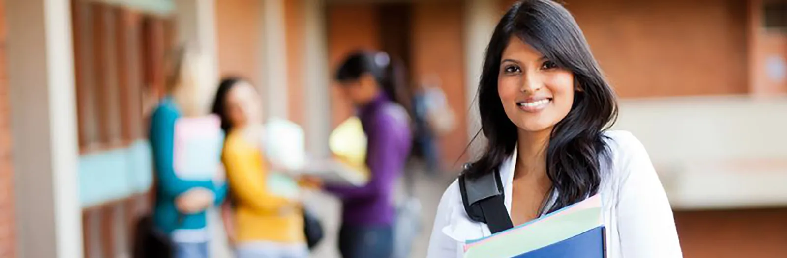 A woman on campus smiling at the camera