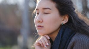 Woman thinking with hand on her chin.