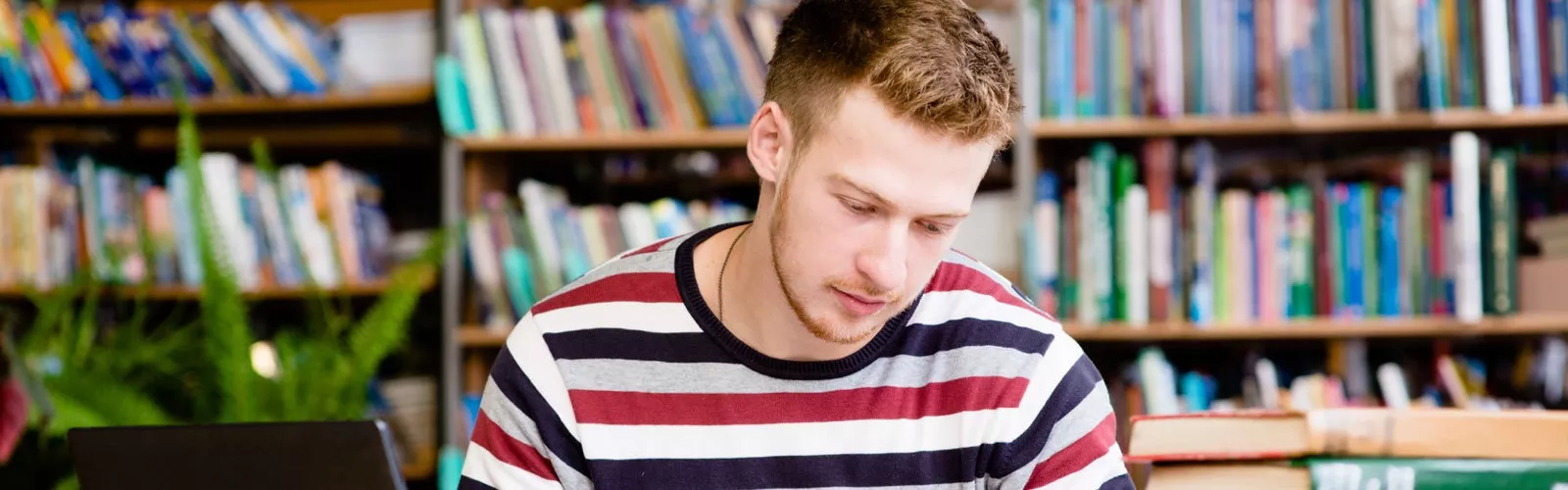 man reading book in library