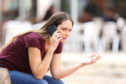 A concerned woman talking on a cell phone