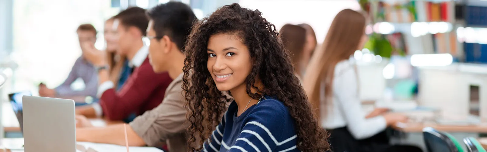 Female student in class smiling at the camera