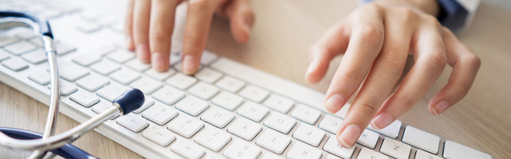 Hands with keyboard and stethoscope