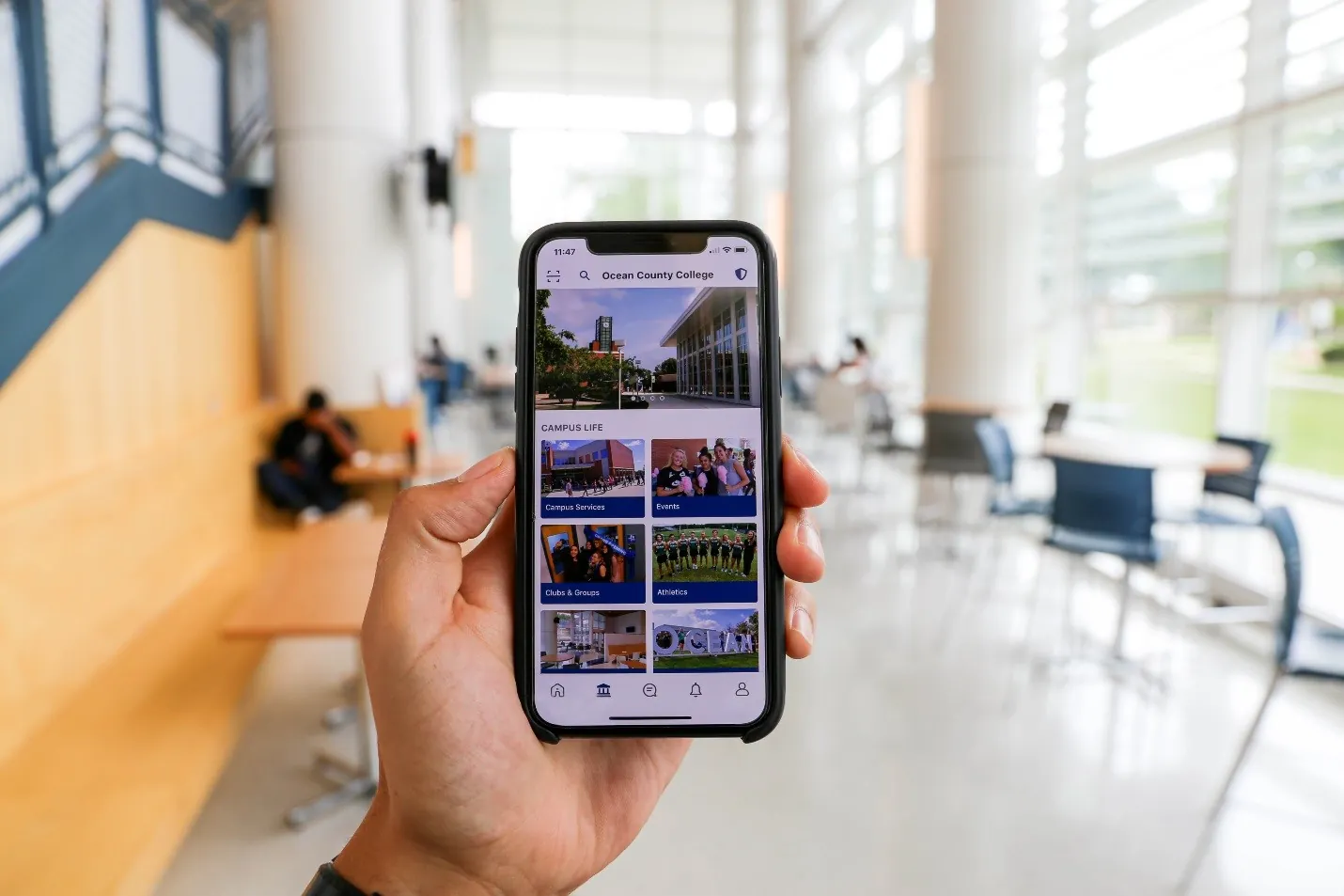 person holding a phone with the OCC app open in the Student Center