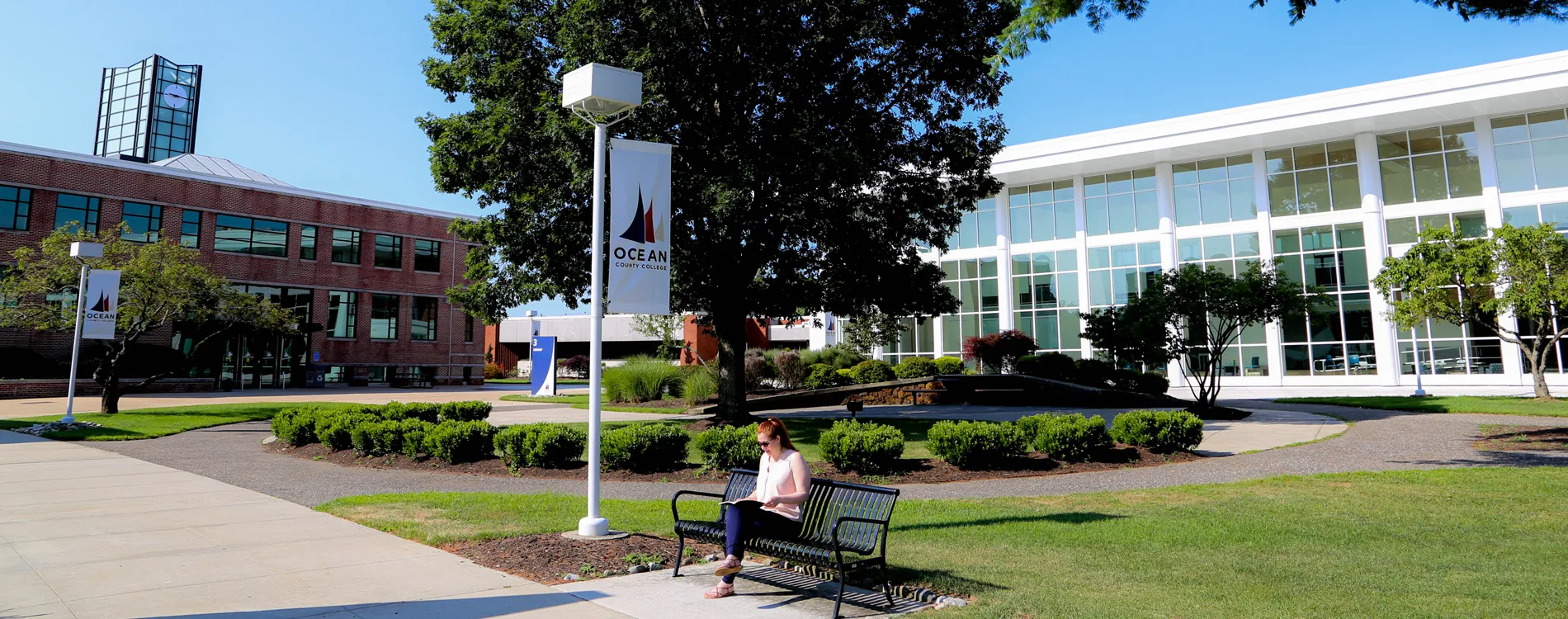 student sitting on bench in front of the instructional building