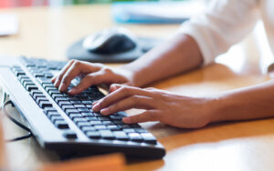 Individual typing on the keyboard at office