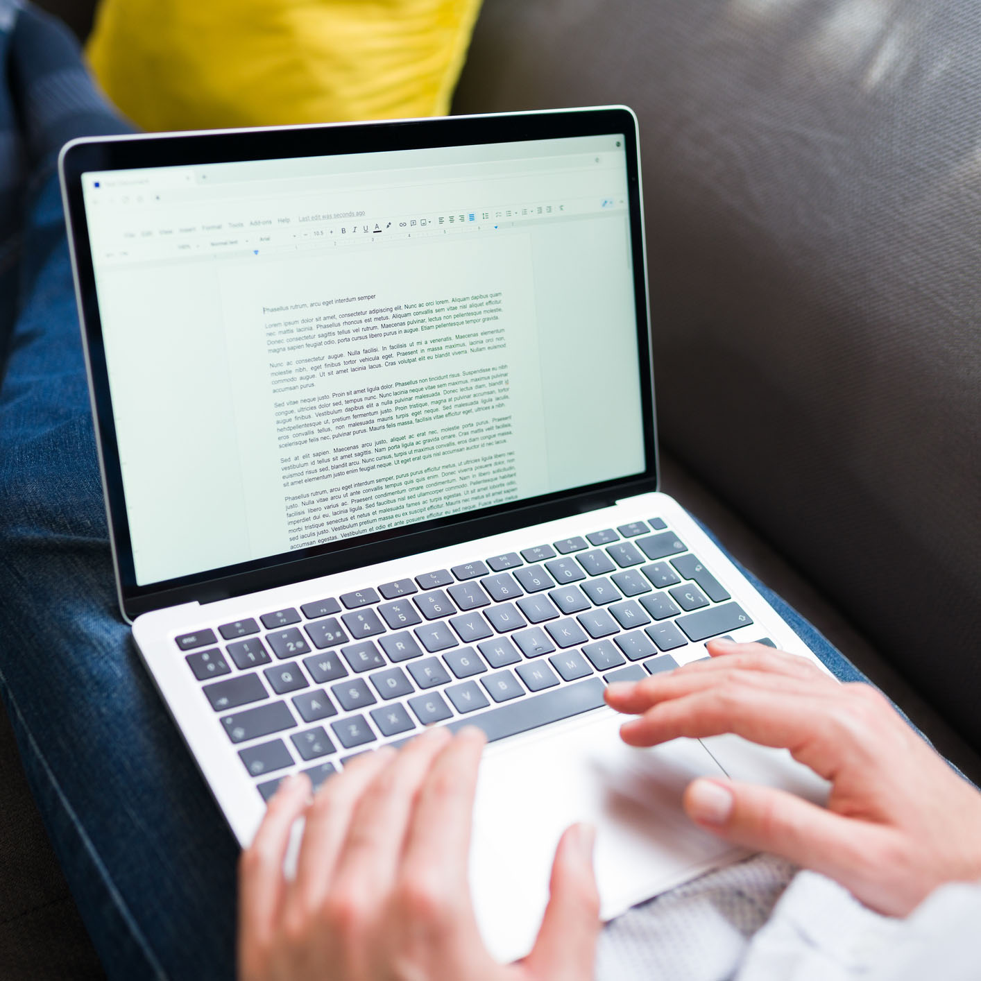 Hands typing an essay on a laptop computer