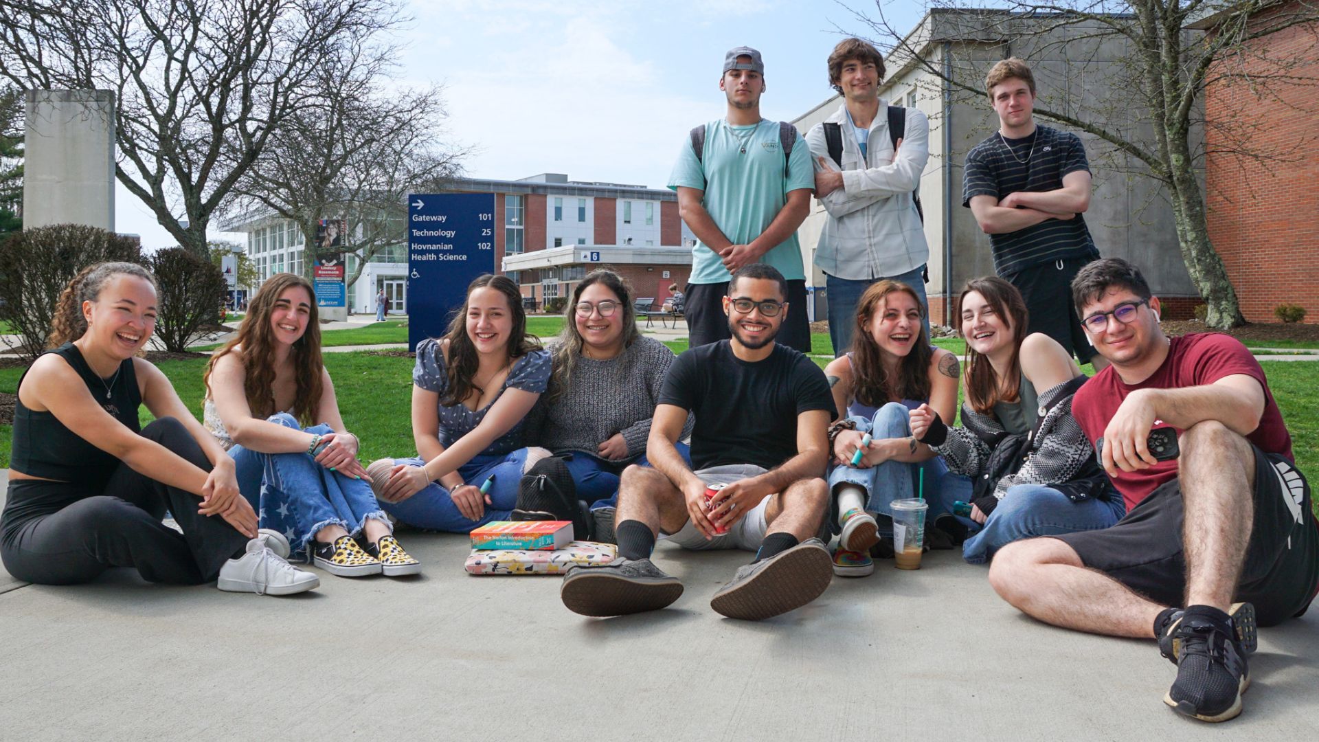 group of students sitting in the campus mall posing for an image