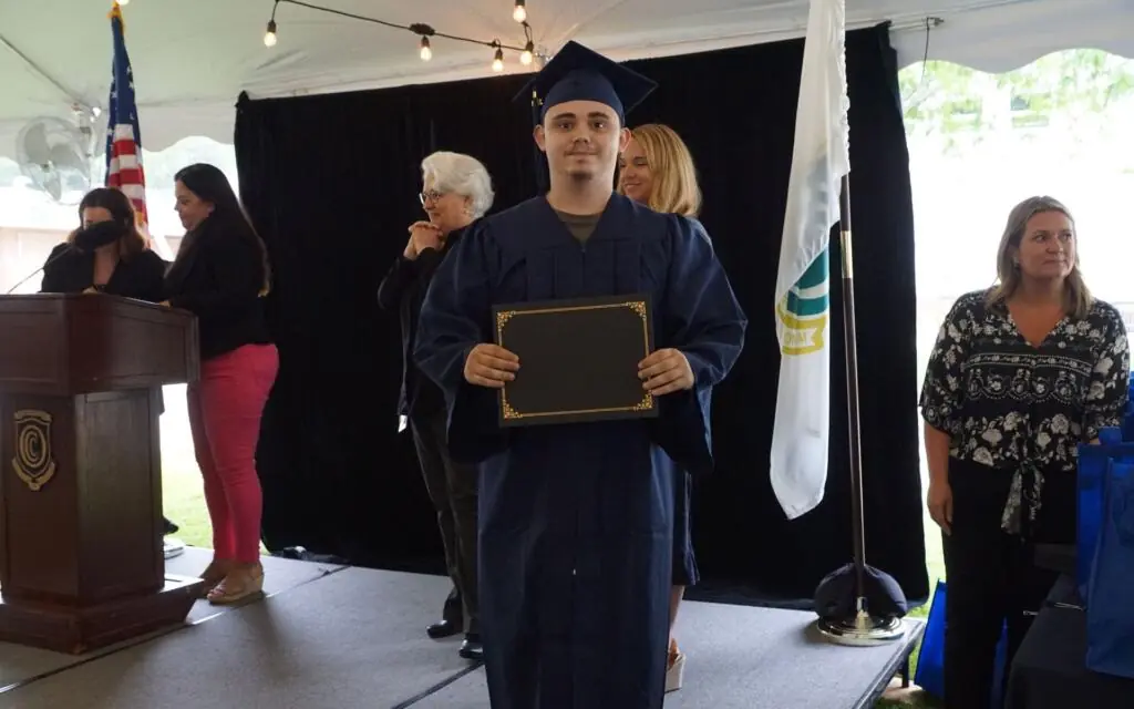 Man holding up his diploma at graduation