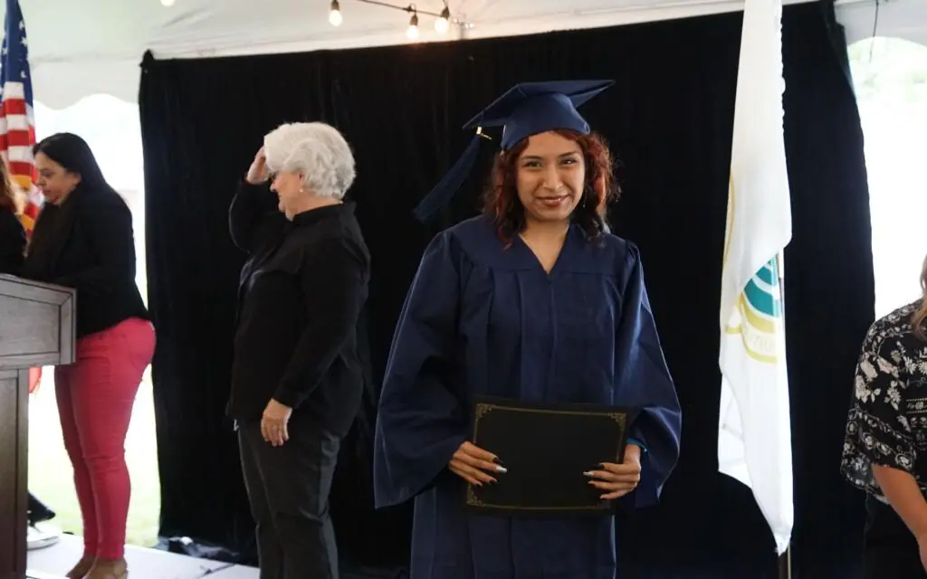 woman in a graduation cap and gown smiling