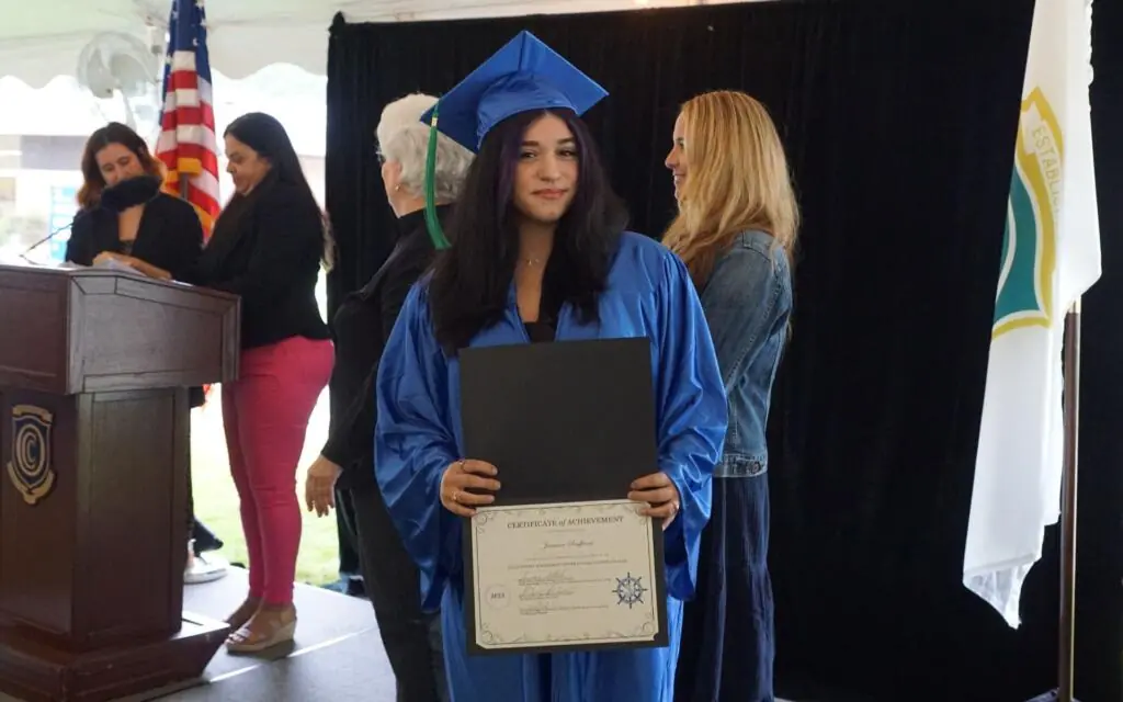 Woman holding her diploma certificate at graduation