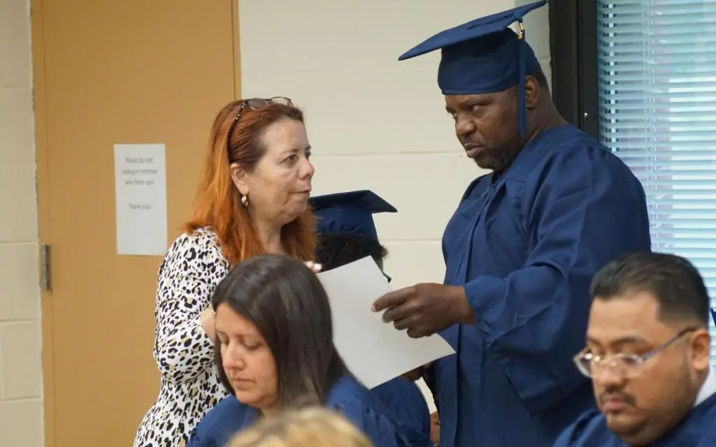 Woman speaking with man in a graduation cap and gown