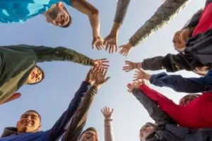 A group of students all putting their hands together