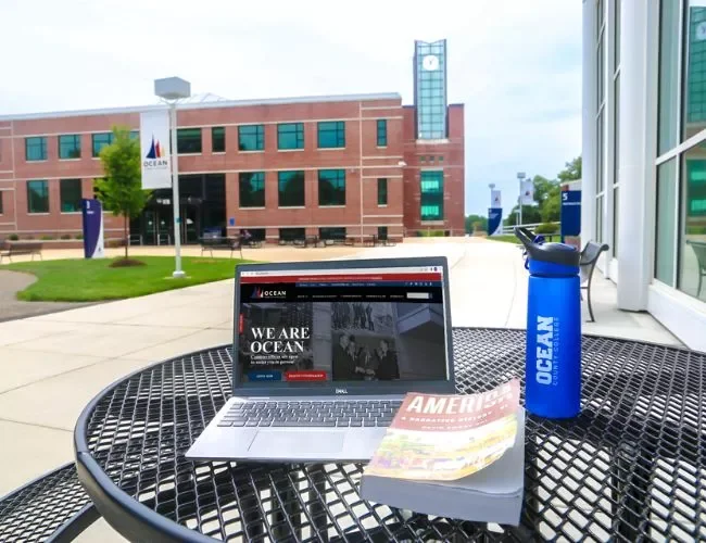 An open laptop on a table outside on campus