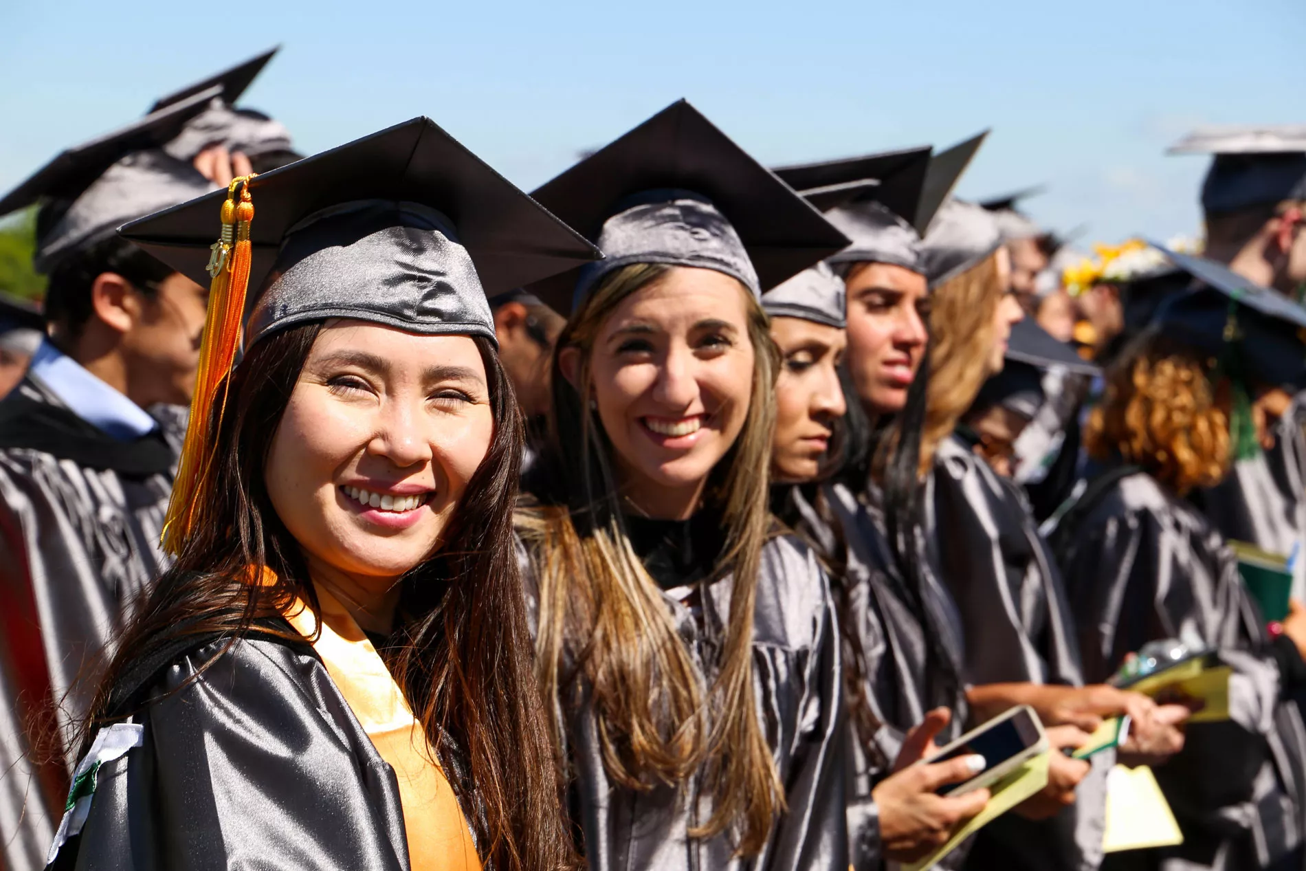 Women smiling at graduation.