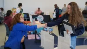 Student and school staff shaking hands at an event.