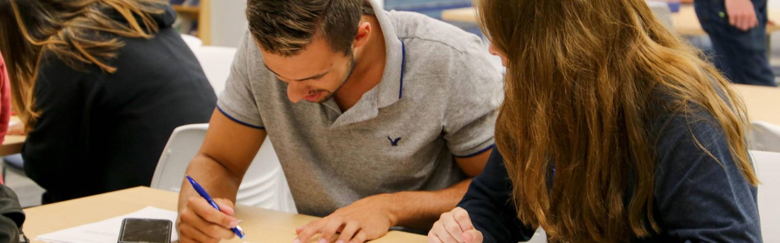 Male and female student working on schoolwork together.