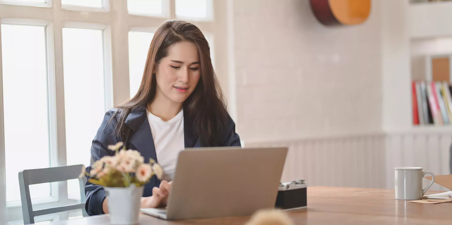 Woman sitting at a table working on a laptop