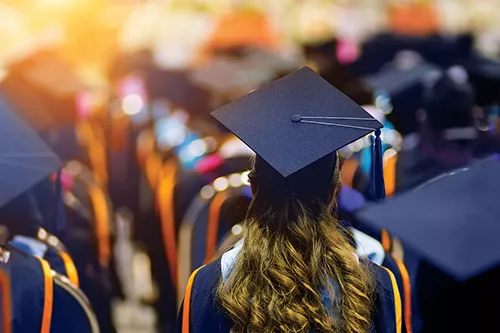 Rear view of the university graduates line up for degree award in the university graduation ceremony.