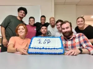 Group of students holding a cake that says "I am EOF"