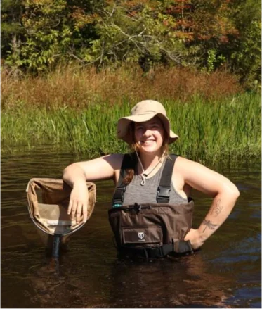 woman standing in a pond with a net