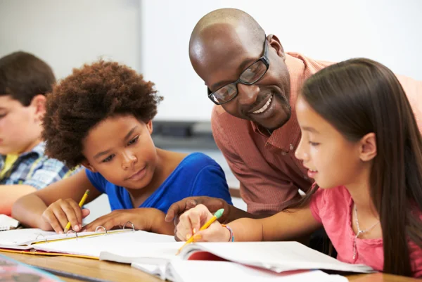 Teacher helping young students