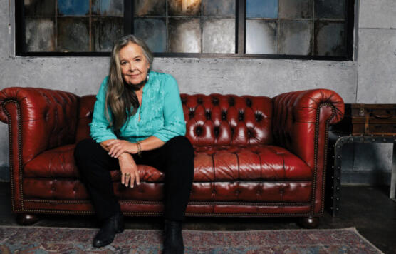 Tracy nelson sitting on a red decorative couch