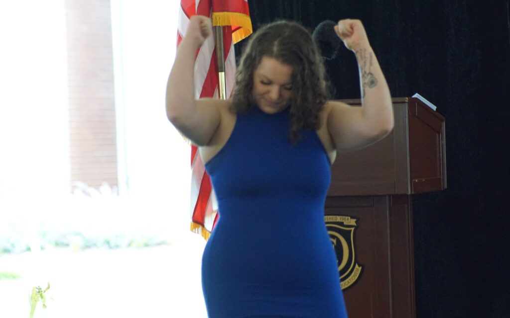 Alumni Megan Rondeau presenting at OCAC Graduation with fists in the air in celebration