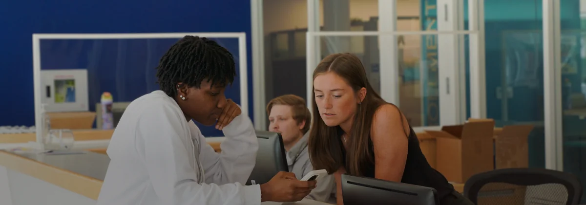 staff helping student in the hub