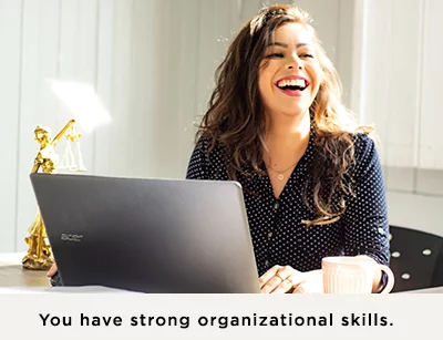 Woman working on a laptop laughing at something