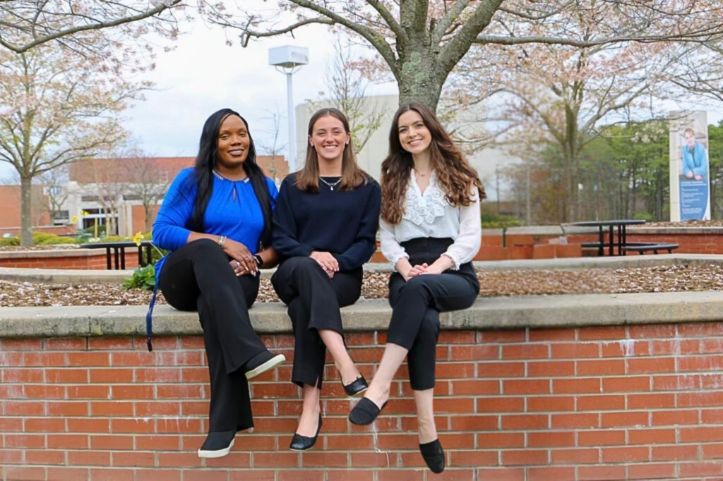 Student Success Coaches sitting on the wall in the campus mall